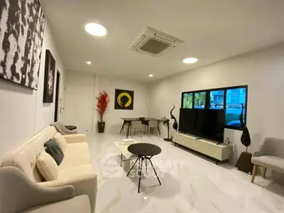 Spacious modern living room with elegant decor and large windows offering natural light.