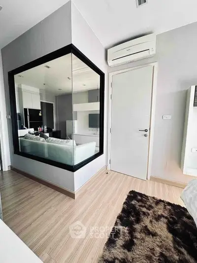 Modern living room with stylish decor and large mirror, featuring sleek air conditioning unit and cozy rug.