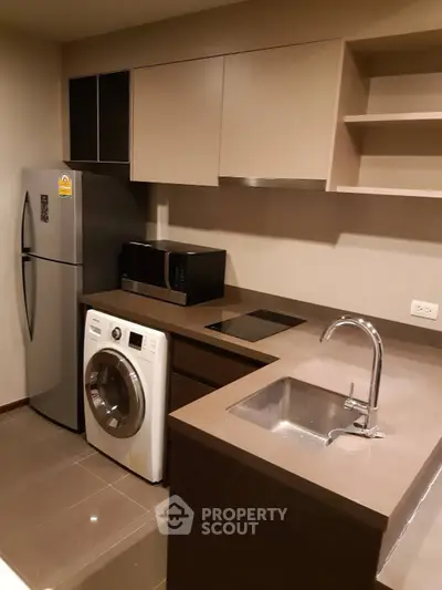 Modern kitchen with sleek appliances and stylish cabinetry in a contemporary apartment.