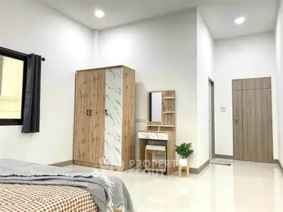 Modern bedroom with stylish wardrobe and vanity set, bright and inviting ambiance.