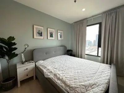 Modern bedroom with stylish decor and city view, featuring a cozy bed and elegant furnishings.