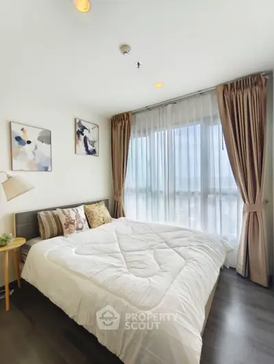 Bright and cozy bedroom with large window and elegant decor in modern apartment.