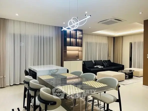 Modern open-plan living and dining area with stylish lighting and contemporary furniture.
