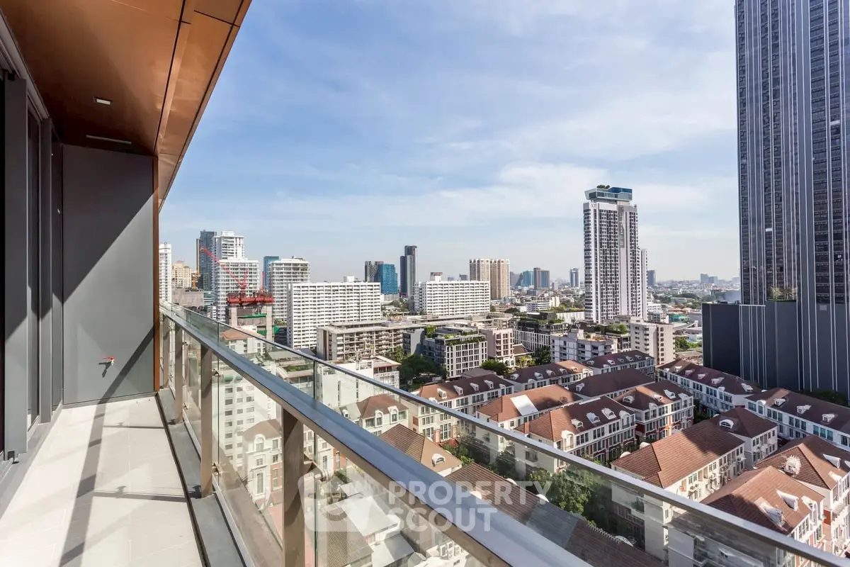 Stunning cityscape view from a high-rise balcony with modern glass railing.