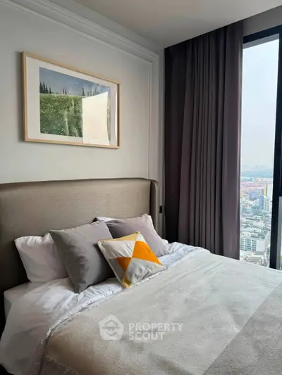 Modern bedroom with city view, stylish decor, and cozy bedding