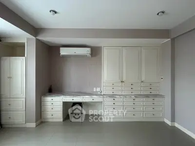 Spacious study room with built-in cabinets and air conditioning, perfect for a home office setup.