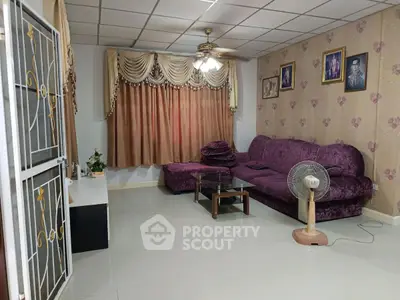 Cozy living room with plush purple sofa and elegant curtains