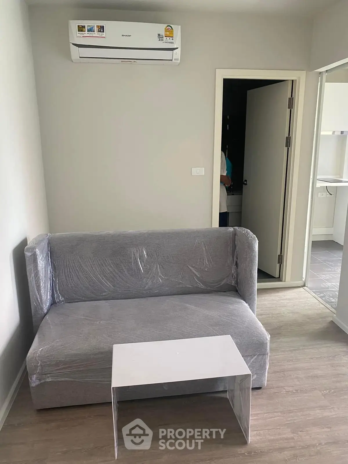 Modern living room with air conditioning and compact sofa in a cozy apartment.