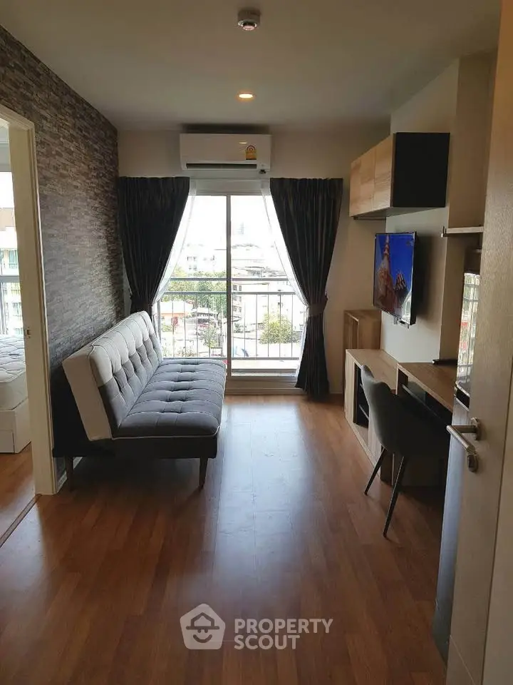 Modern living room with stylish decor and large window offering natural light and city views.