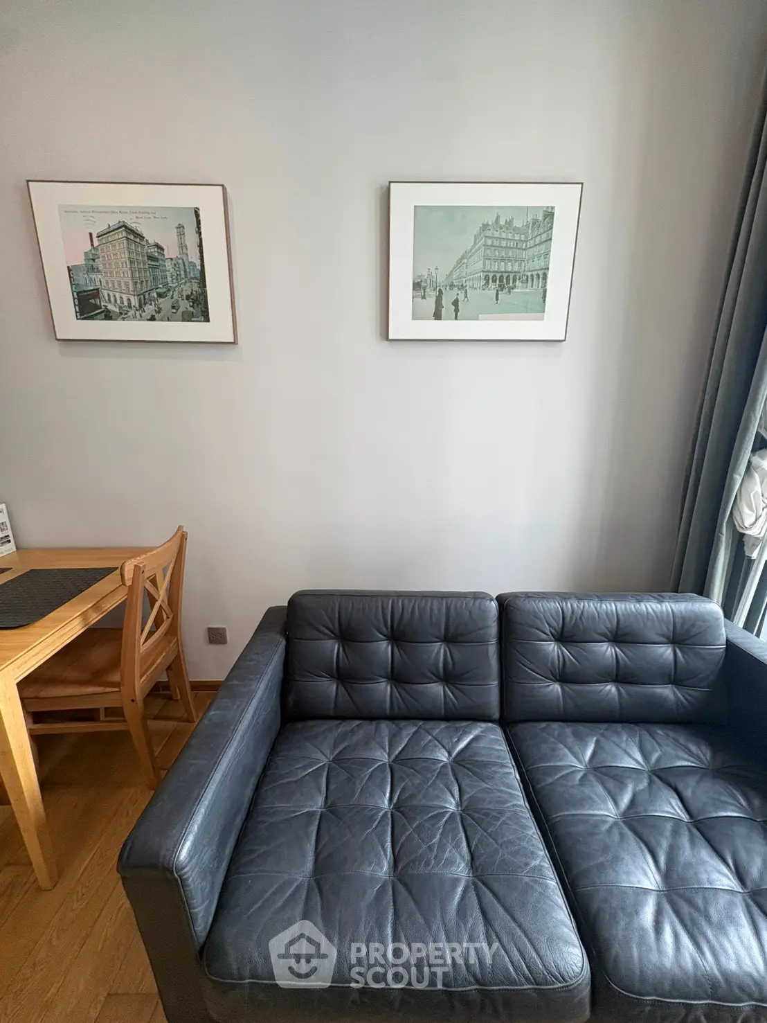 Stylish living room with black leather sofa and elegant wall art, perfect for modern urban living.