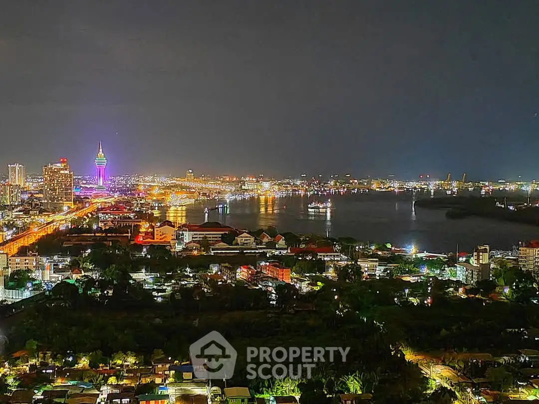 Stunning cityscape view with vibrant night lights and riverfront panorama.