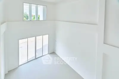 Spacious white interior with large windows and high ceiling