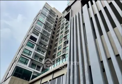 Modern high-rise building with sleek architectural design and large windows.