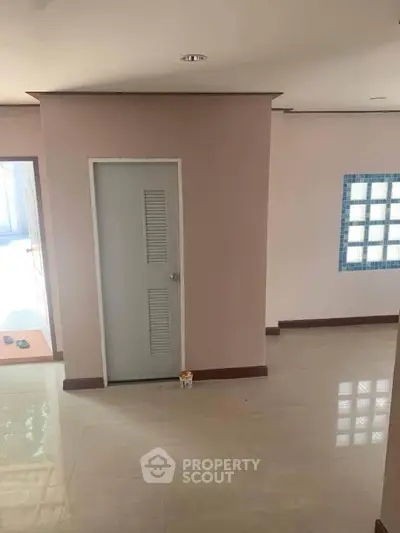 Spacious interior with tiled floor and modern door, perfect for customization.