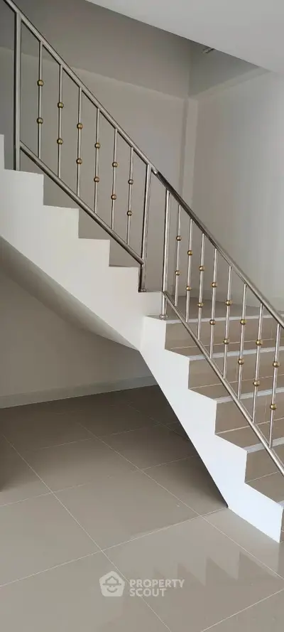 Modern staircase with sleek metal railing in a contemporary home interior.