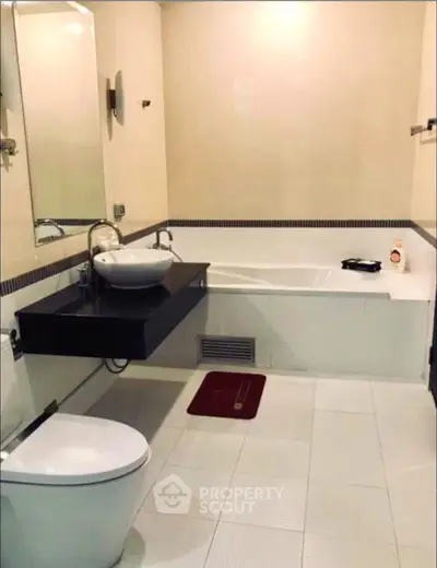 Modern bathroom with sleek fixtures and spacious bathtub in a contemporary home.