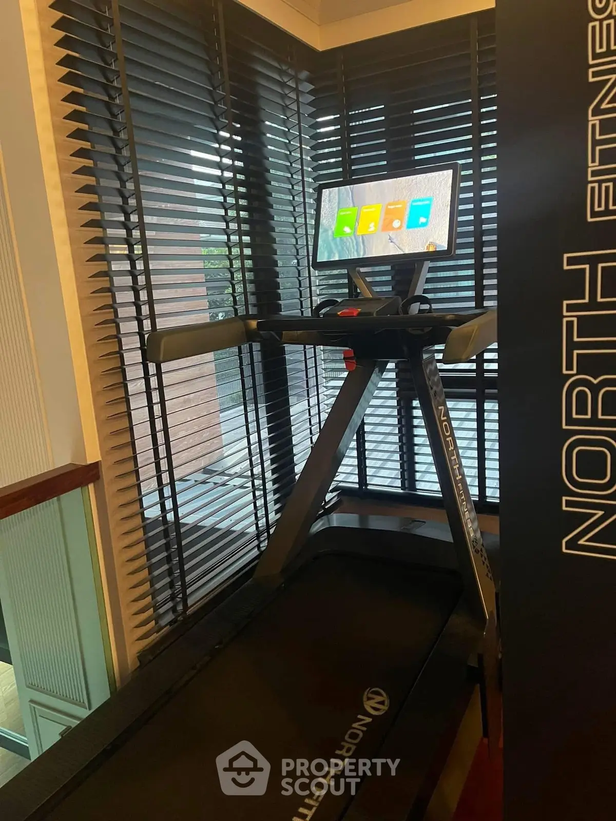Modern home gym with treadmill and digital display in stylish corner setup.