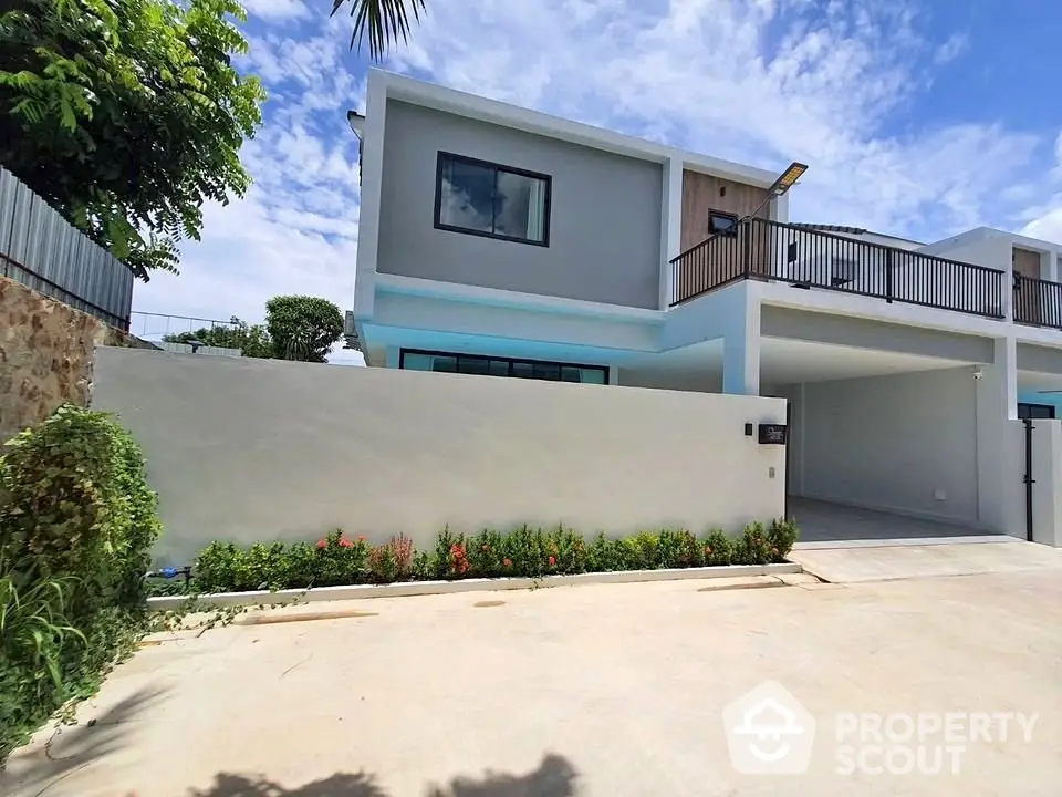 Modern two-story house with spacious driveway and lush greenery