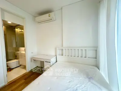 Bright bedroom with ensuite bathroom and air conditioning in modern apartment.