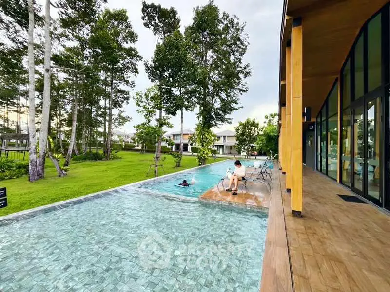 Luxurious poolside view with modern architecture and lush greenery.