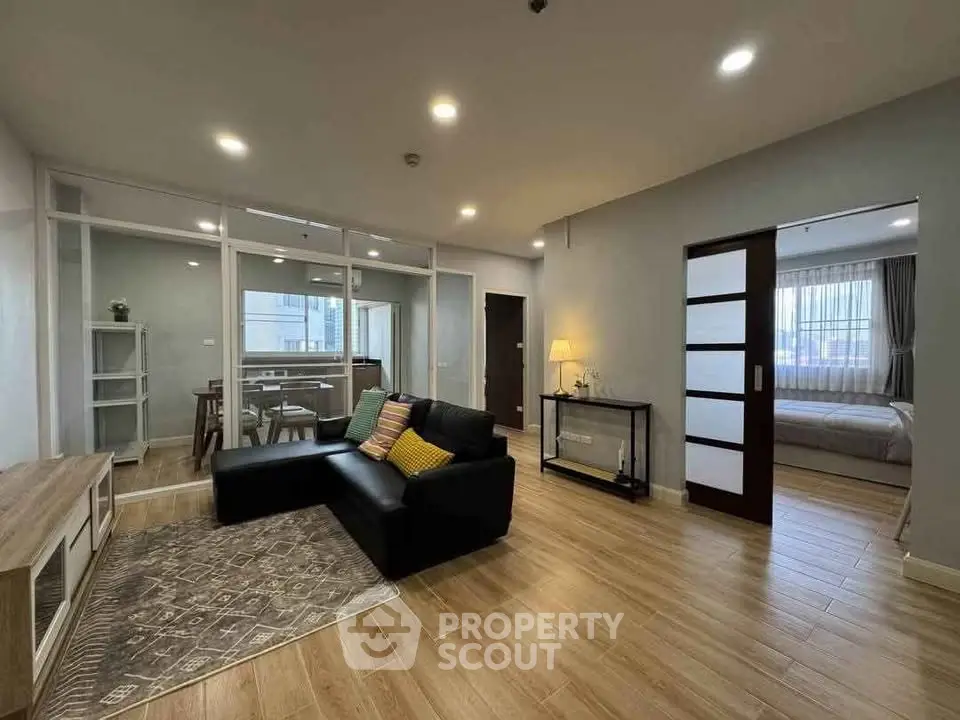 Spacious modern living room with wooden flooring and stylish decor in a contemporary apartment.