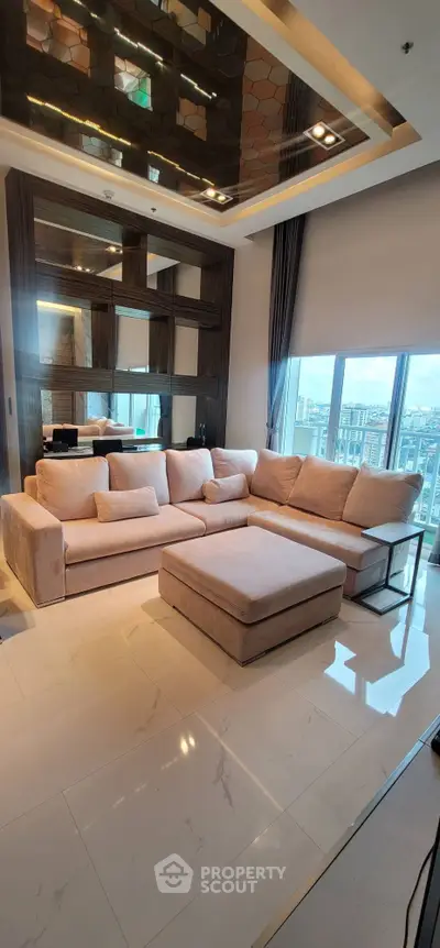 Luxurious living room with plush sectional sofa and stunning city view, featuring elegant ceiling design and large windows.