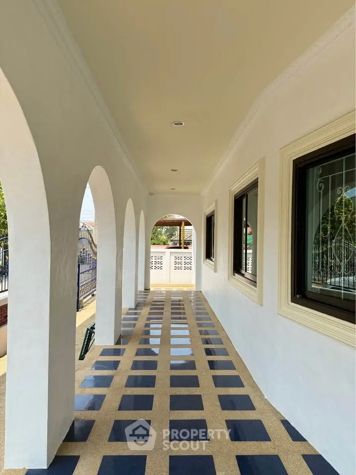 Elegant corridor with arched design and checkered flooring in a luxurious property