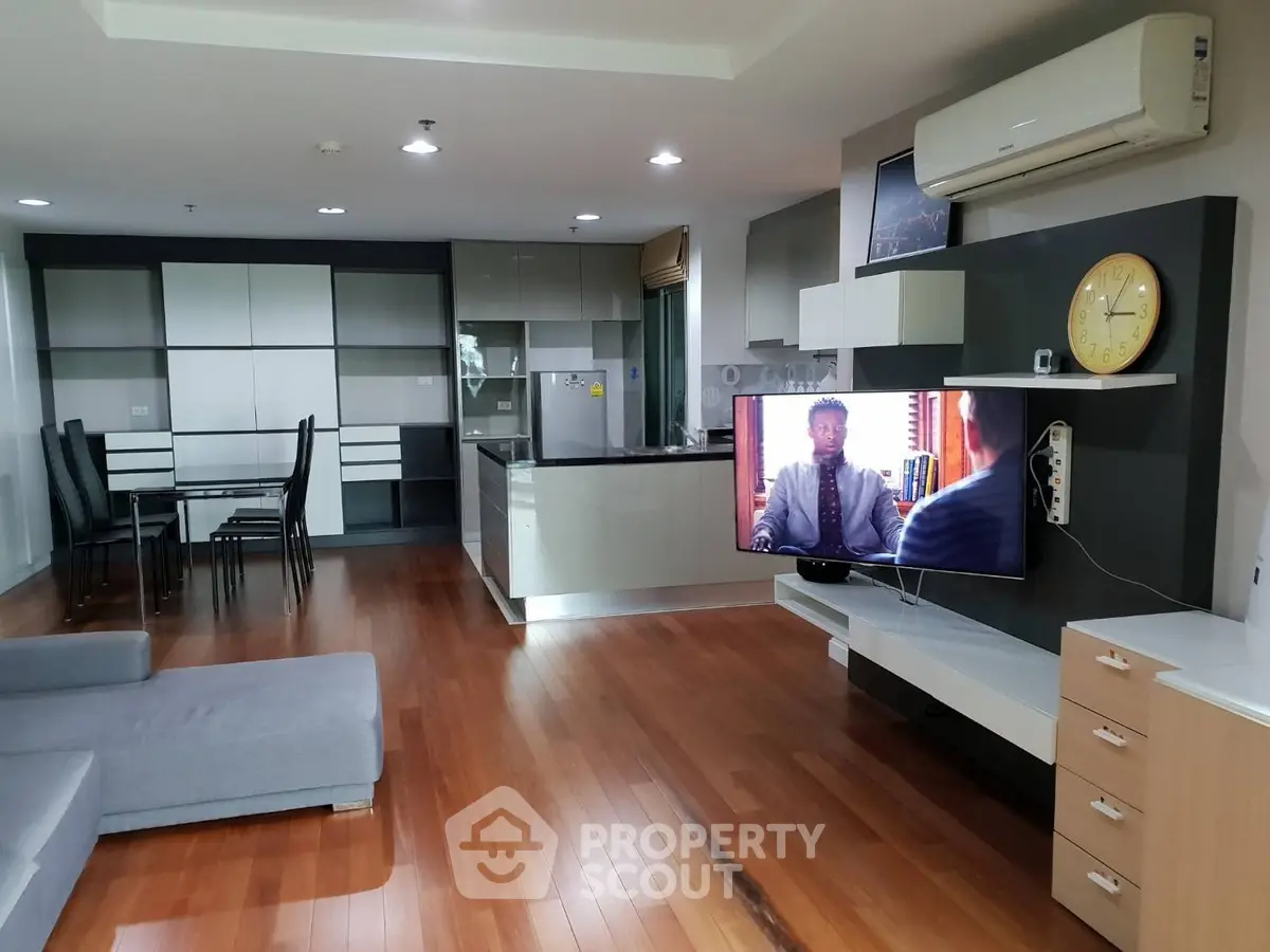 Spacious modern living room with open kitchen and sleek wooden flooring