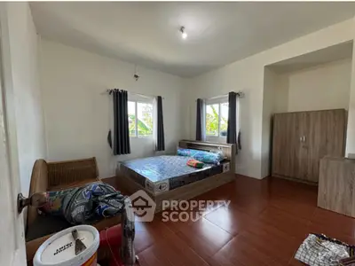 Spacious bedroom with natural light and modern furnishings in a cozy home.