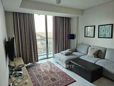 Cozy living room with large sectional sofa and floor-to-ceiling windows offering natural light and a view.