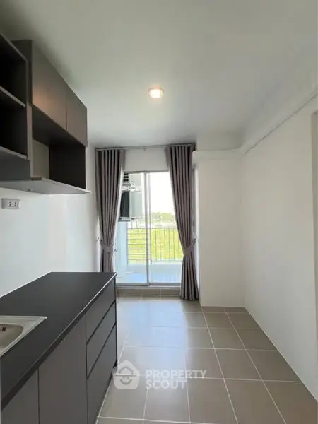 Modern kitchen with sleek cabinets and balcony view