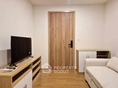 Modern living room with wooden flooring, sleek TV stand, and cozy white sofa.