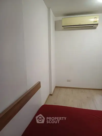 Minimalist bedroom with air conditioning and wooden flooring