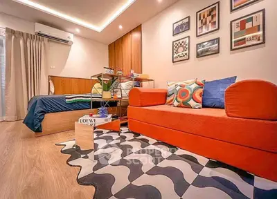 Stylish modern living room with vibrant orange sofa and artistic decor