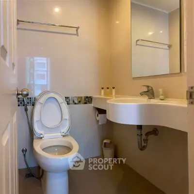 Modern bathroom with sleek fixtures and a large mirror, perfect for a contemporary home.