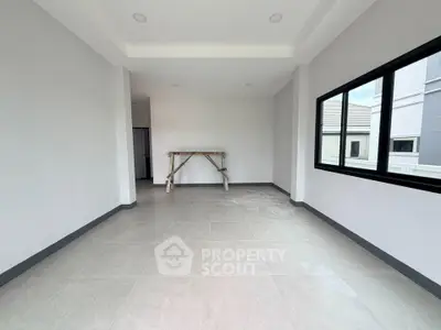 Spacious unfurnished room with large windows and modern tile flooring in a new property.