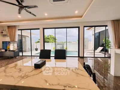 Luxurious open-plan living room with pool view and elegant marble dining table.