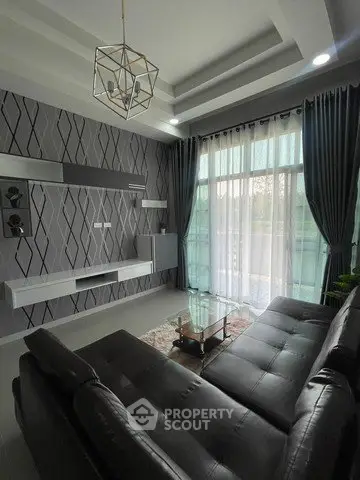 Modern living room with stylish decor and large windows offering natural light.