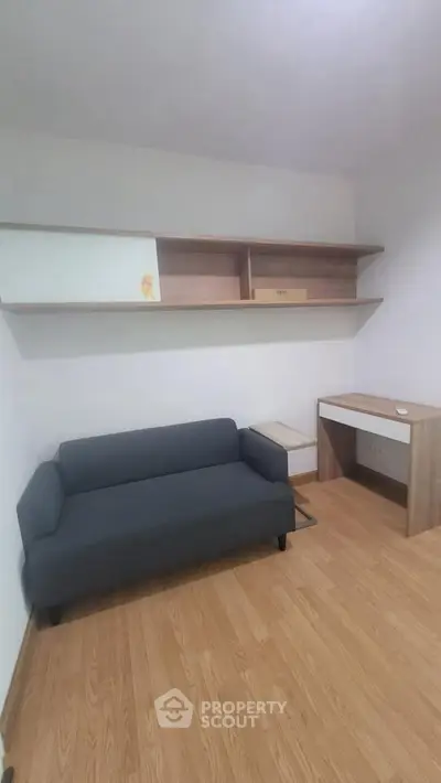 Modern minimalist living room with sleek sofa and wooden shelves