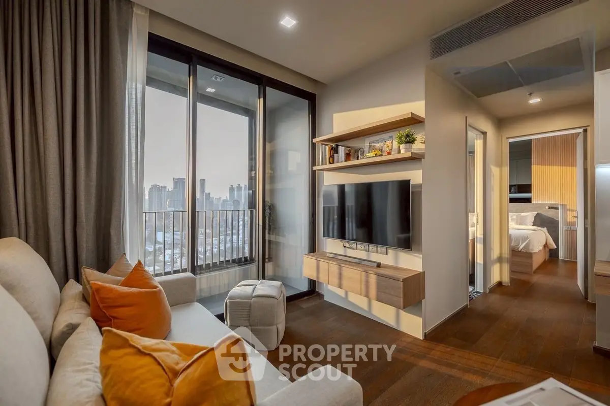 Modern living room with city view, cozy seating, and stylish decor in a high-rise apartment.