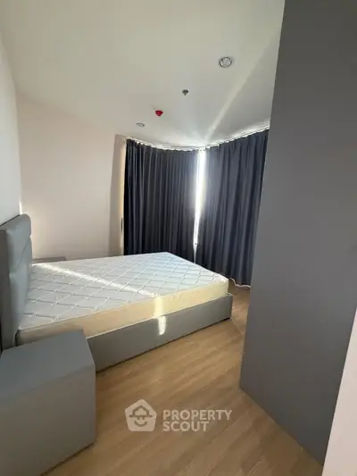 Modern bedroom with minimalist design and large window with curtains