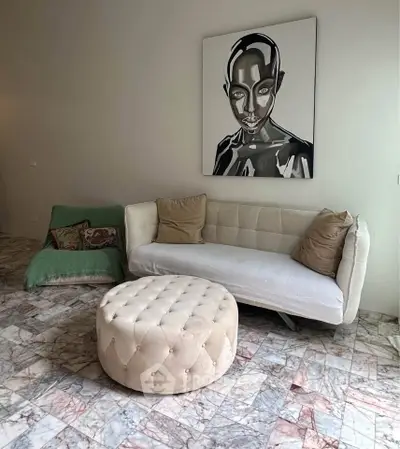 Stylish living room with modern art, plush sofa, and elegant marble flooring.