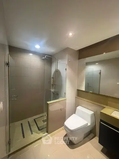 Modern bathroom with glass shower and sleek fixtures in a contemporary home.