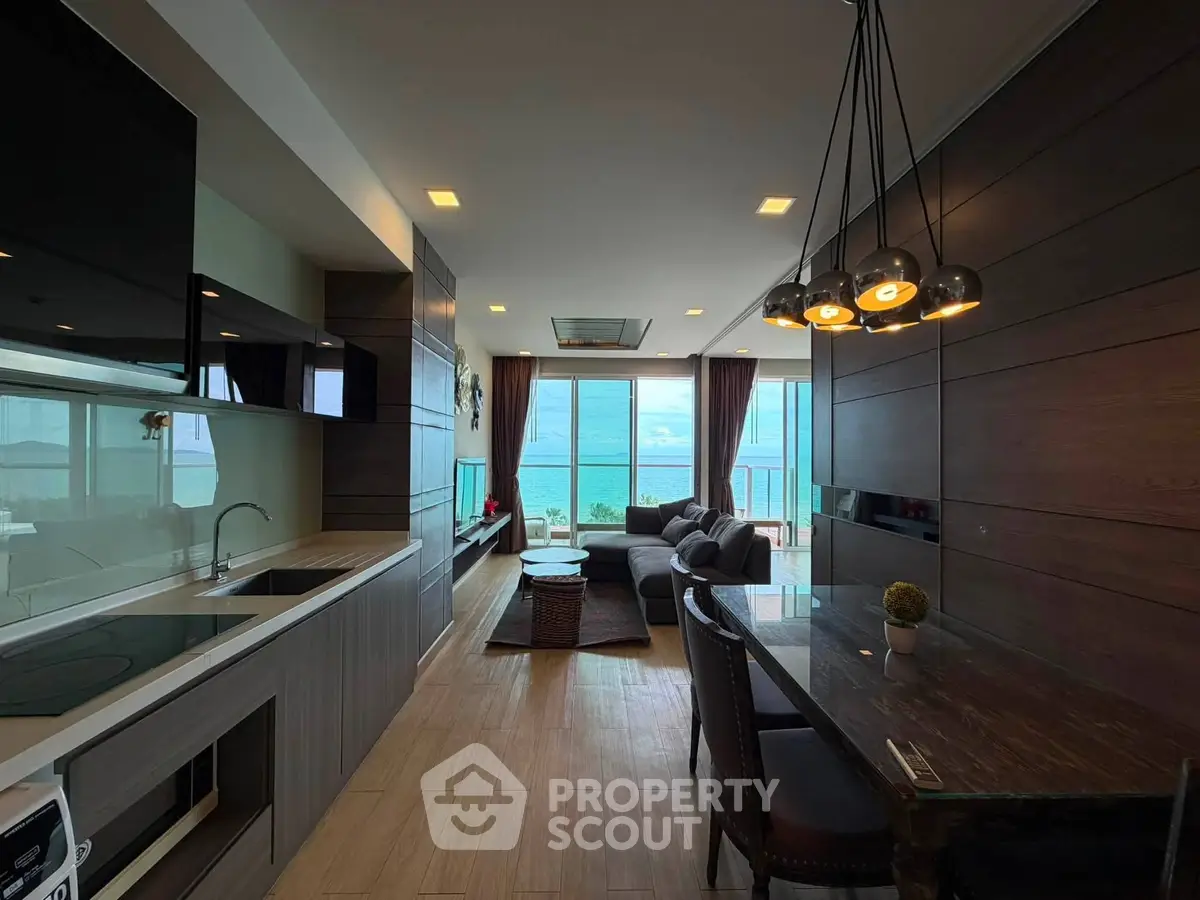 Luxurious beachfront living room with stunning ocean view and modern open kitchen.