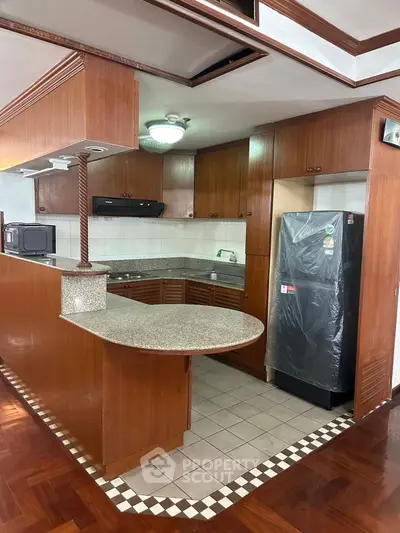 Charming kitchen with wooden cabinetry and modern appliances in cozy home setting.