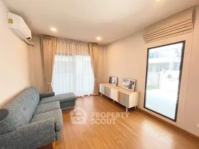 Modern living room with stylish furniture and large window offering natural light.