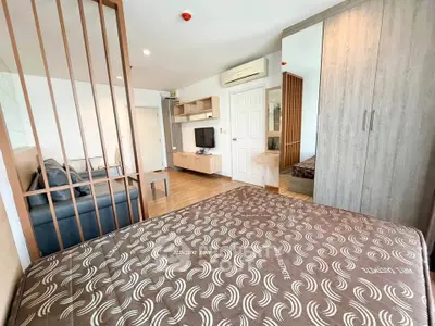 Modern studio apartment with stylish decor and open layout, featuring a cozy living area and sleek bedroom.