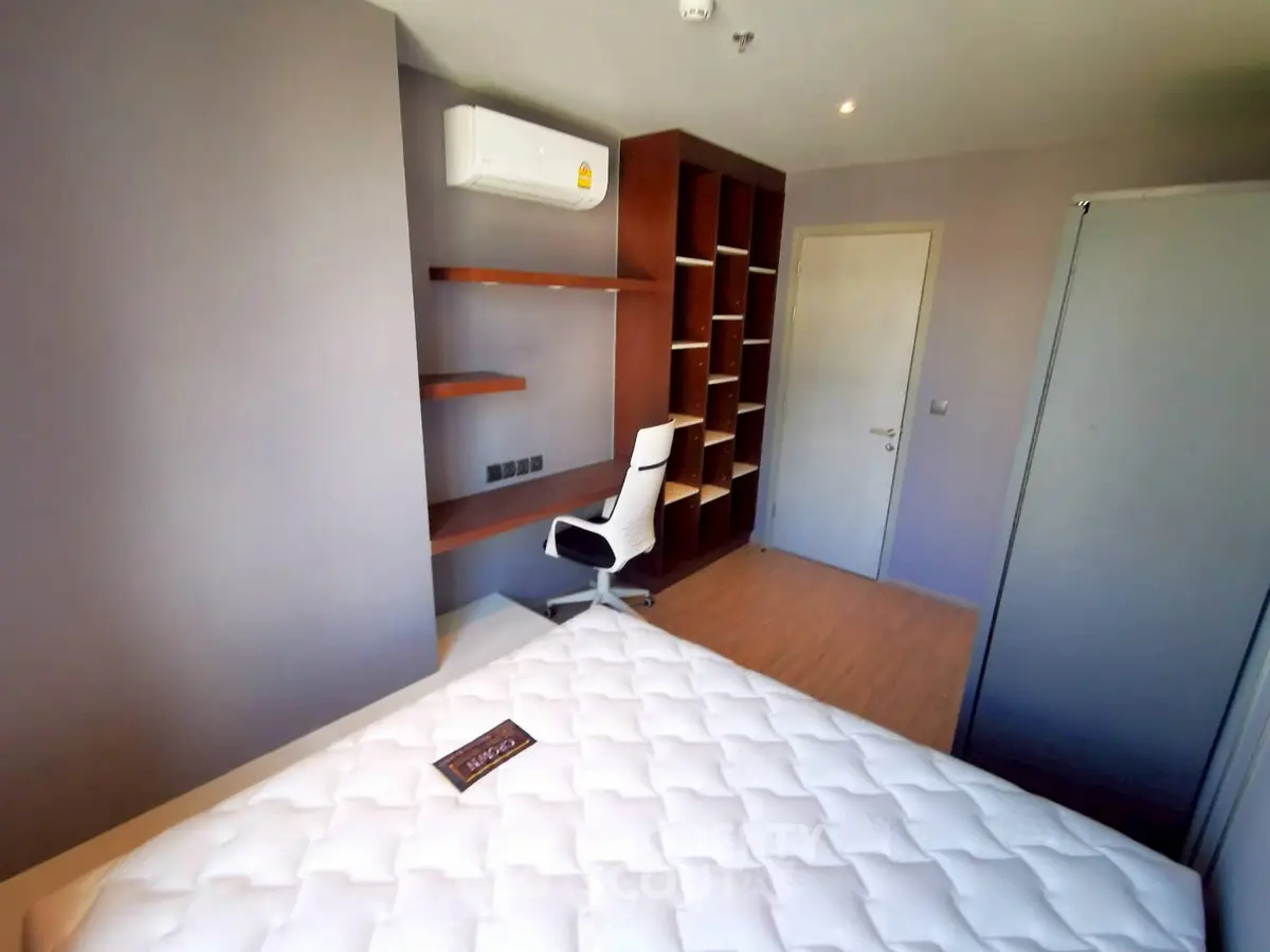 Modern bedroom with built-in shelves and air conditioning, ideal for comfort and organization.