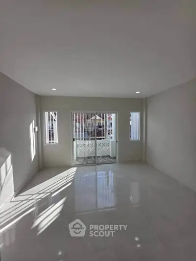 Spacious empty room with large windows and balcony access, perfect for customization.