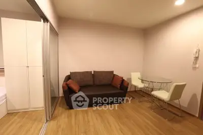 Modern living room with cozy sofa and glass dining table in a stylish apartment.